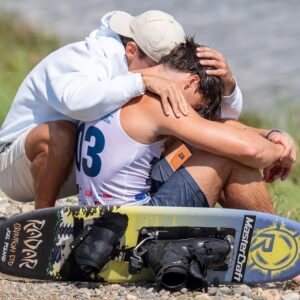 Joel Poland of Great Britain is consoled by friend Edoardo Marenzi of Italy after Poland fell early in his trick run during the 2025 IWWF World Waterski Championships at Parco Nautico del Sesia in Novara, Italy.